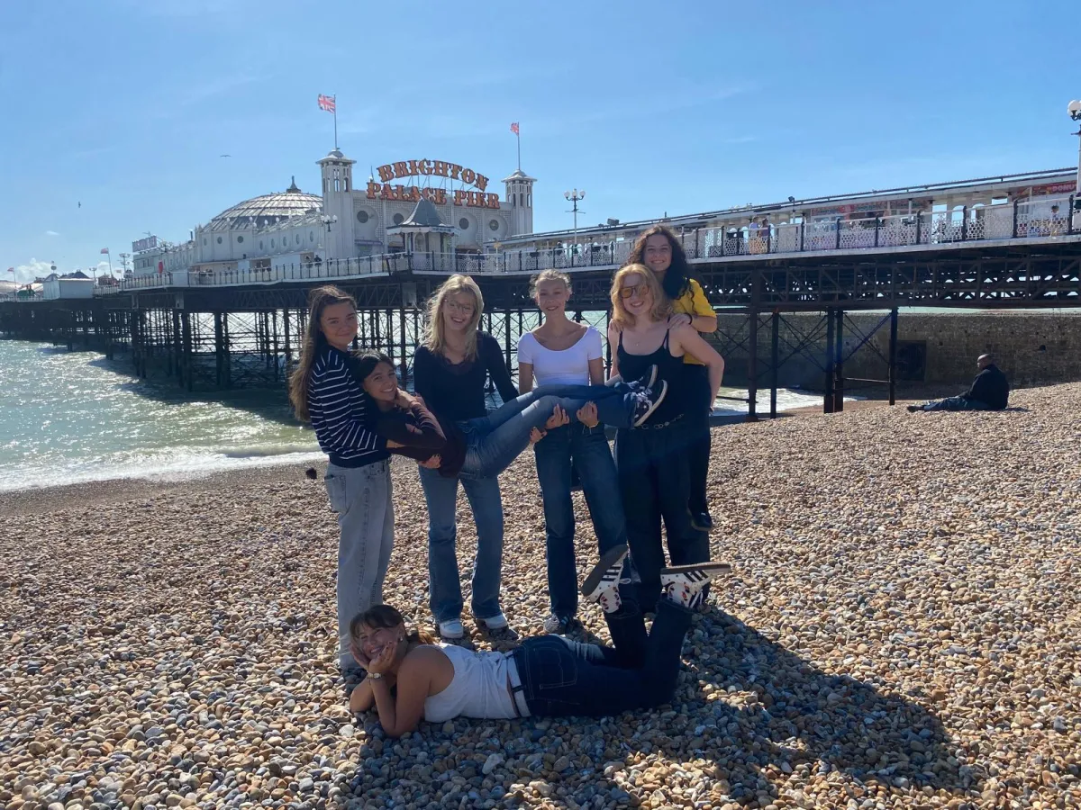 Junge Leute am Strand vor Pier in Südengland