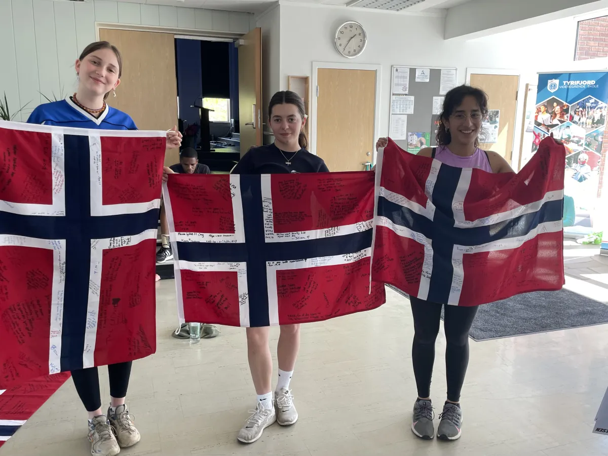 Drei Schülerinnen mit norwegischer Flagge in der Schule