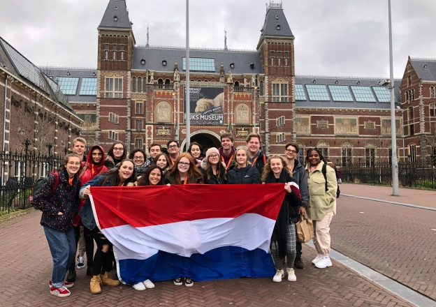 Gruppenbild Austauschschüler vor dem Bahnhof Amsterdam mit niederländischer Flagge