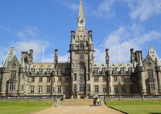 Prachtvolles Schloss mit Trümen blauer Himmel grüne Wiese