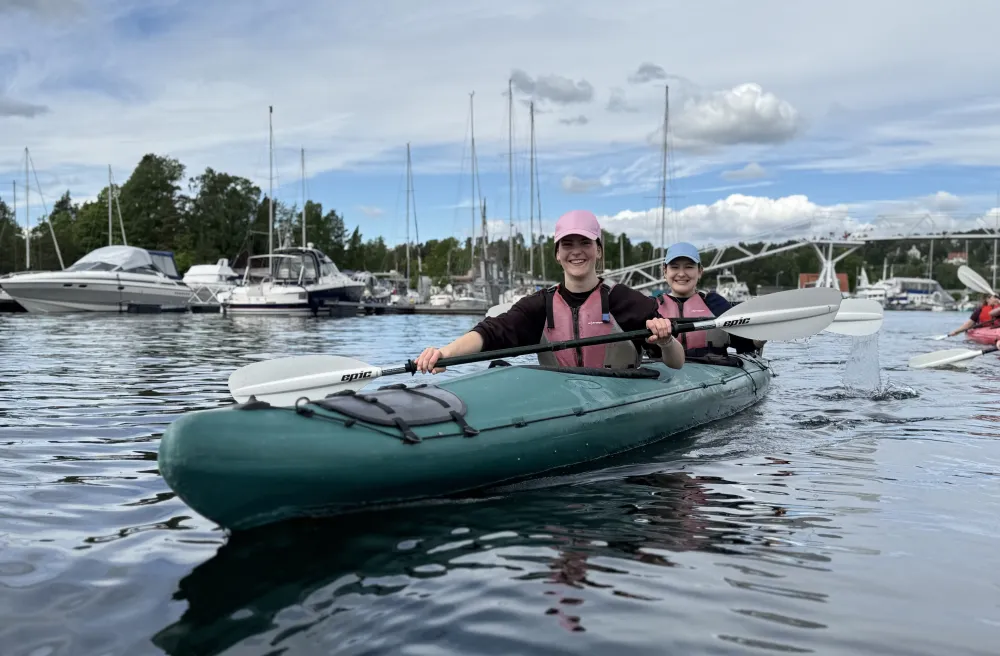 Zwei Schülerinnen im Kayak im Hafen bei Sommerwetter. 